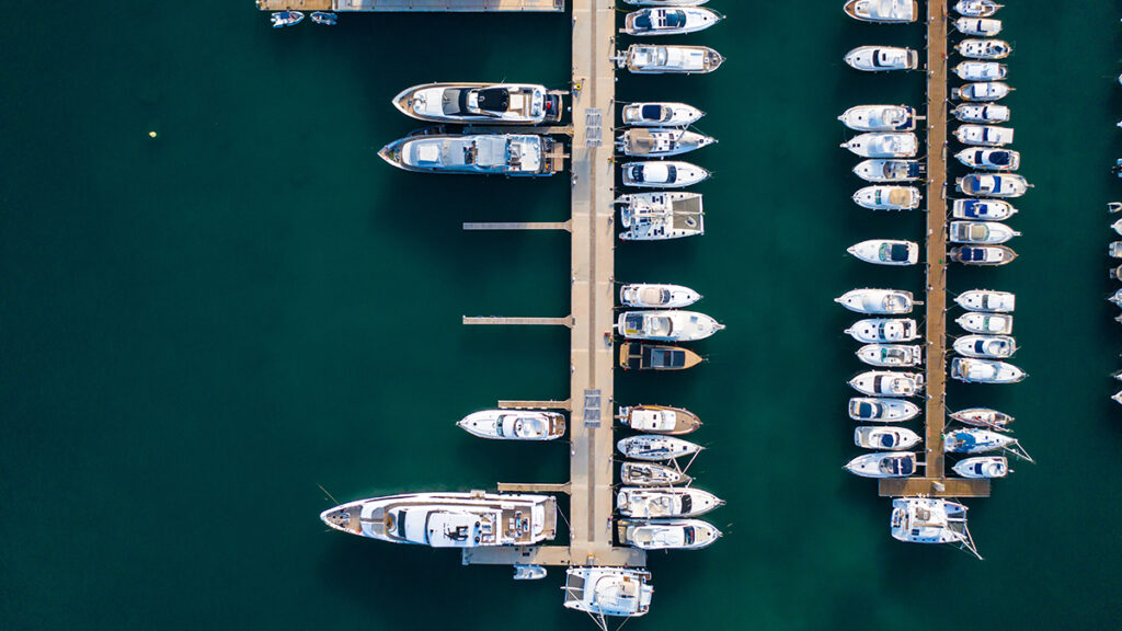 Se observan yates y embarcaciones amarrados en una dársena de un puerto deportivo.