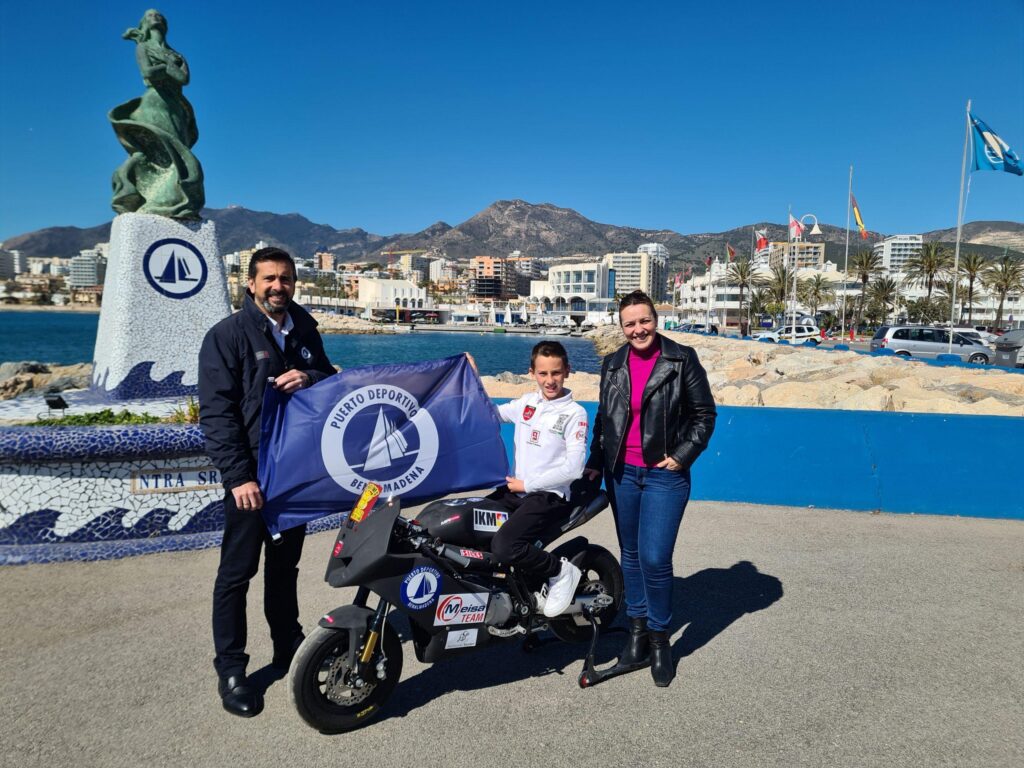 Autoridades del puerto deportivo junto al joven que va a disputar el campeonato montado en la moto con la que competirá.
