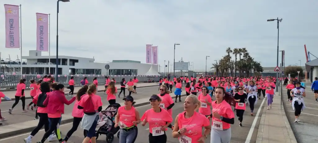 Personas corriendo en la carrera contra el cancer de mama.